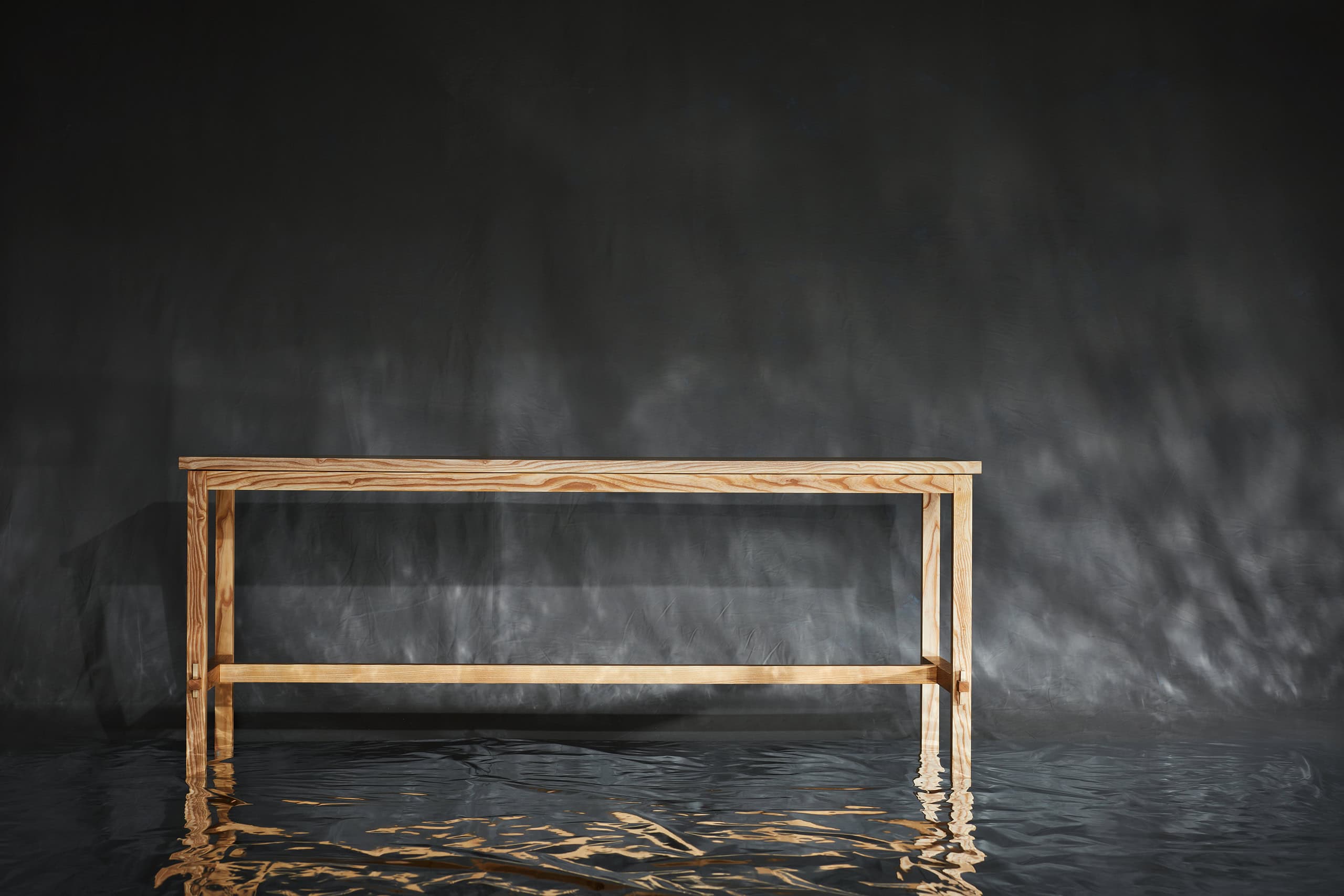 Elegante Holzbank am Wasser, reflektiert im ruhigen Wasser, natürliche Atmosphäre, nachhaltiges Holz., Esstisch — holz bewegt 2025