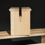 Holzsäge mit Holzblock auf einer Werkbank, Fokus auf nachhaltiges Holzhandwerk.