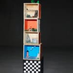 Holzspielzeugregal mit bunten Fächern und Spielzeug, auf schwarzem Hintergrund.